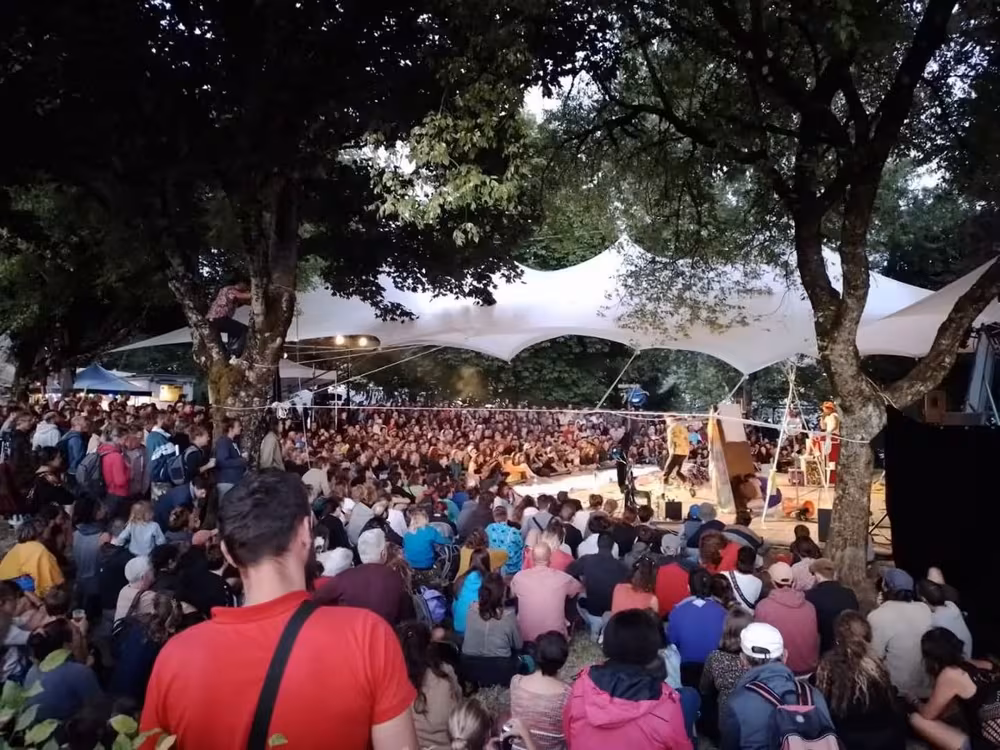 Le Cirk biZ'arT en spectacle au festival d'Aurillac 2022, sous la grande toile blanche du Collectif À Toile, tendue entre les arbres, devant une foule assise par terre