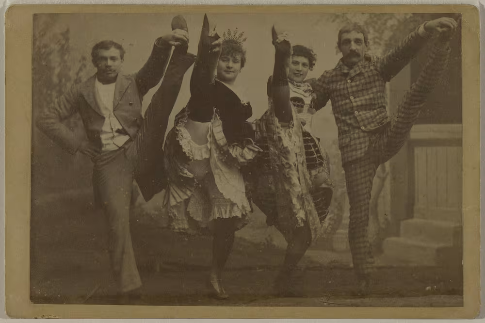 Photographie ancienne : de gauche à droite, un danseur non identifié, La Goulue, Grille d'Égout et Valentin le Désossé, levant la jambe